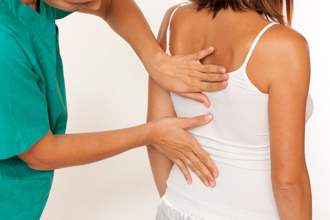 the doctor examines the back for pain in the area of ​​the shoulder blades